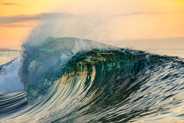 istock Smooth curved wave in the ocean with golden sky at dusk 1740250170