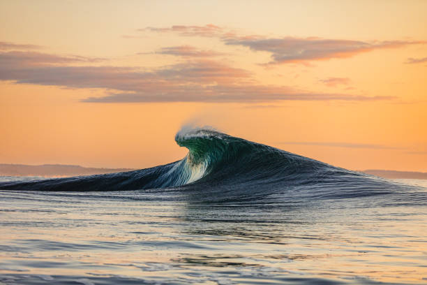 istock Smooth curved wave in the ocean with golden sky at dusk 1740250193
