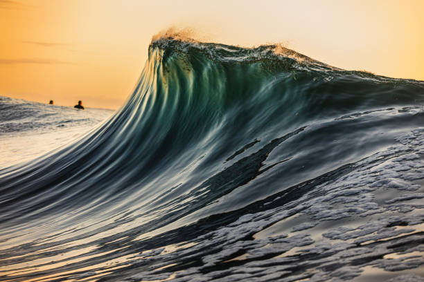 istock Smooth curved wave in the ocean with golden sky at dusk 1740250791