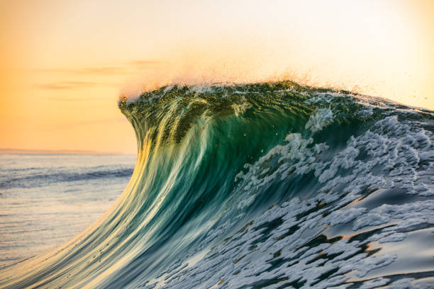 istock Smooth curved wave in the ocean with golden sky at dusk 1740251323