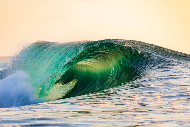 istock Powerful wave breaking in the ocean with golden sky at dusk 1740251341