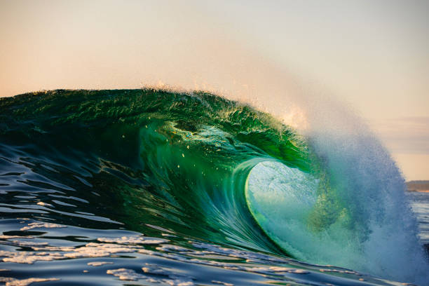 istock Powerful wave breaking in the ocean with golden sky at sunrise 1740251933