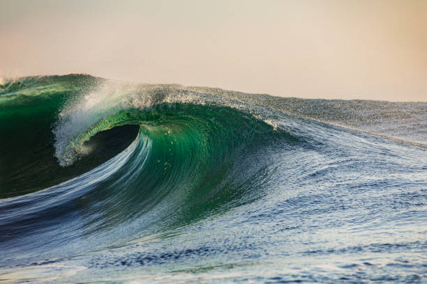 istock Smooth curved wave in the ocean with golden sky at sunrise 1740252482