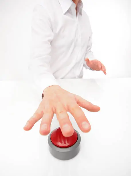 Hand of a man hitting an unlabled  buzzer. extreme wide-angle lens used.