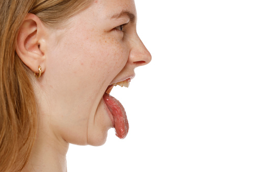 Close up of a blond woman mouth sticking tongue on a white studio background