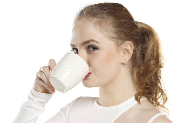 istock Beautiful young blond woman drinking coffee on white background 1740256922