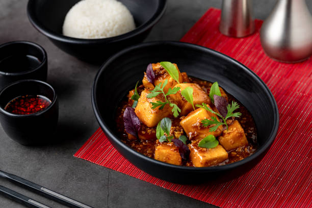 istock Mapo Tofu bowl with side sauces on black stone table 1740257487
