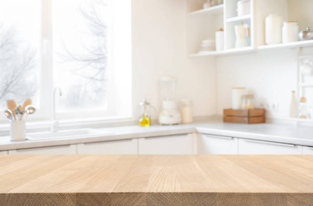 istock Blurred modern kitchen interior background with wooden table space for product montage 1740262274