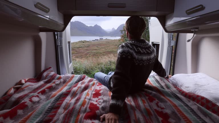 Slow Motion: Road trip- Man at the back of his camper van, autumn