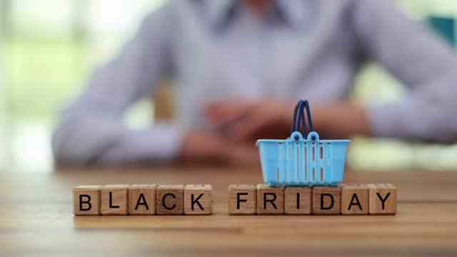 Woman puts shopping basket on phrase from cubes Black Friday
