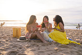 Multi-ethnic friends enjoying together eating watermelon in the beach
