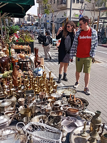 Young couple walking around Jaffa  Market in Tel Aviv. This vibrant flea market area also known as Shuk HaPishpeshim, is also the place of many art and design studios and top-quality restaurants.