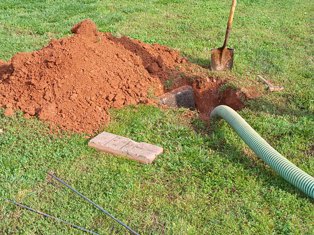 Open Septic Tank In Yard While Bring Pumped Out Seen here is a dug out open septic tank being pumped out.  All the required tools are laying in the yard. poisonous stock pictures, royalty-free photos & images