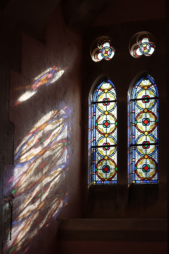 Stained glass window in a chapel illuminated by sunlight