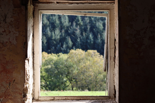 Looking through the window of an abandoned farmhouse