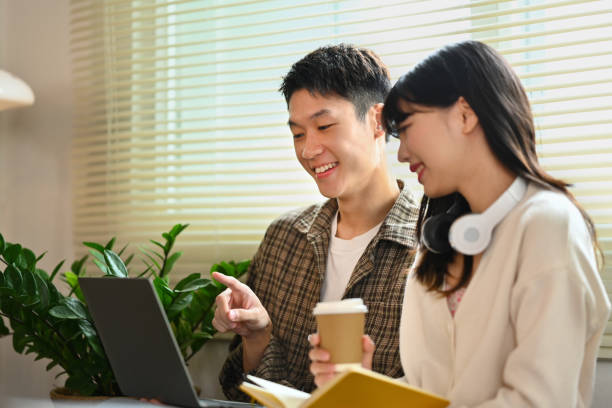 istock Male and female students using laptop and working on academic project together in library. Education and youth lifestyle concept 1740346856