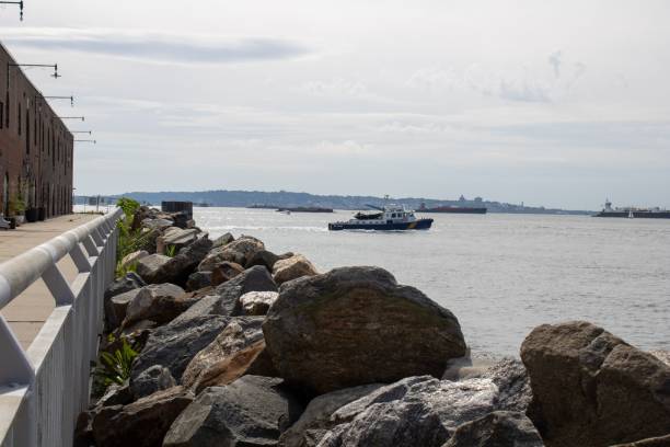istock Boat passing by a large rock wall in a river. 1740353999