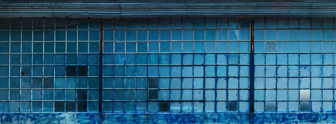 Old factory warehouse grid windows with broken glass as industrial background