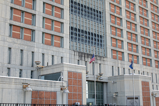 Washington, DC USA - June 5, 2019: Entrance sign, reflecting pool and star shaped fountain of the American Veterans Disabled for Life Memorial in front at Health & Human Services building in Washington, DC with American and POW MIA flags