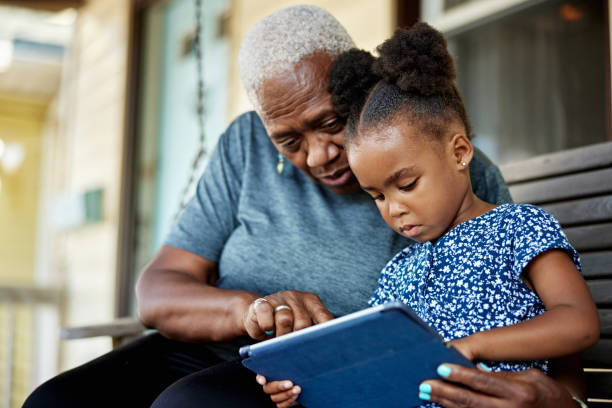 istock Young Black girl and grandmother using digital tablet 1740373822