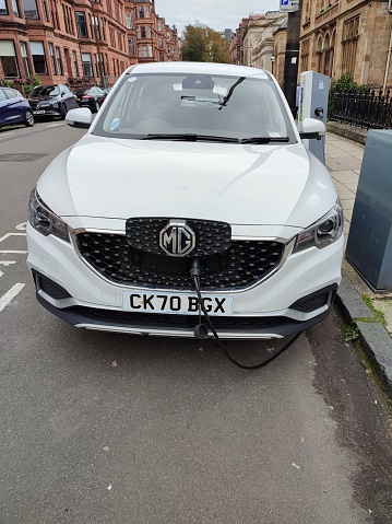 Charging electrical vehicle in street of glasgow scotland england