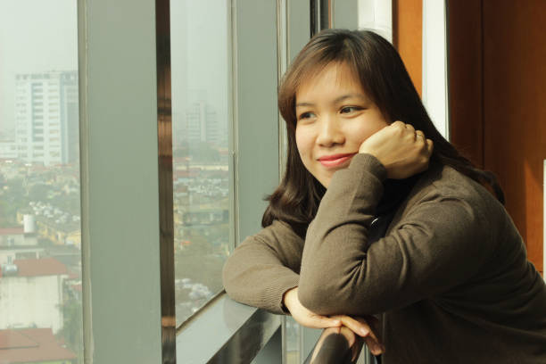 istock A beautiful woman is looking outside from the window 1740382280