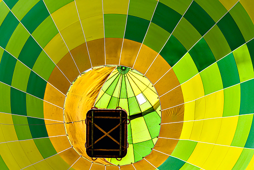 Colorful hot air balloon flying over blue sky with white clouds