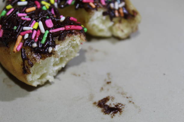 A bitten doughnut with berry filling on a white background. one decorated chocolate covered doughnut. selective focus