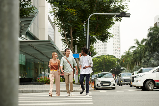 Group of young people crossing road in city downtown