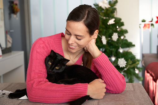 Girl with her cat with christmas decoration