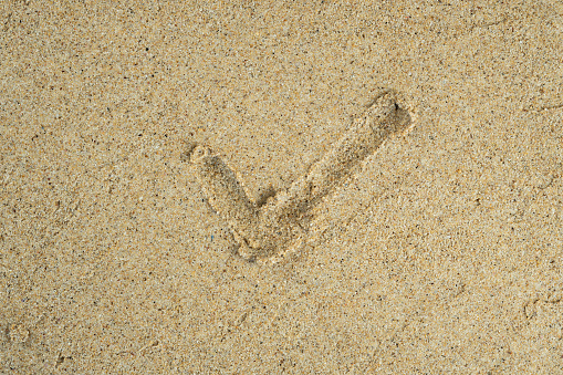 checklist drawn on beach sand surface