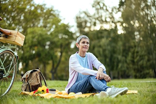 Woman rests in the park while sitting on the grass