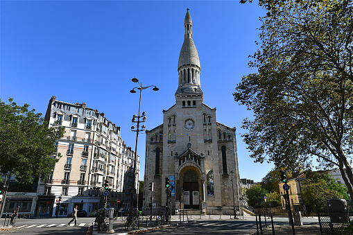 Paris, France-09 24 2023: Pedestrian passing in front of the church of Auteuil in Paris, France.