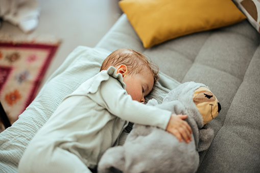 Cute little baby sleeping in sofa at home.