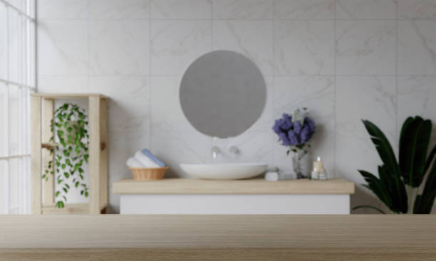 istock 3D render with blank space and counter with top wood with washbasin and modern style white bathroom 3d render, white wall and mirrors, The room has large windows. 3d render 1740451560