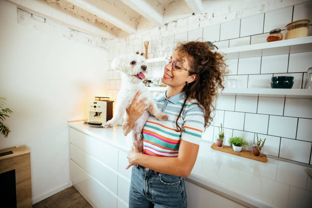 istock Woman in the kitchen with her dog 1740462386