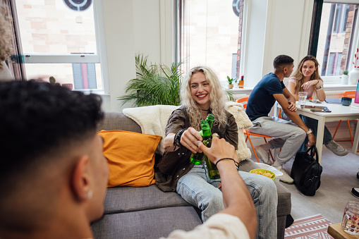 An over the shoulder view of a group of students sitting having a non alcoholic beverage after a day of lectures. They are in the common room of their university in Newcastle Upon Tyne in the North East of England