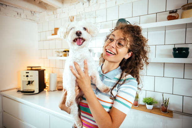 istock Woman in the kitchen with her dog 1740466376