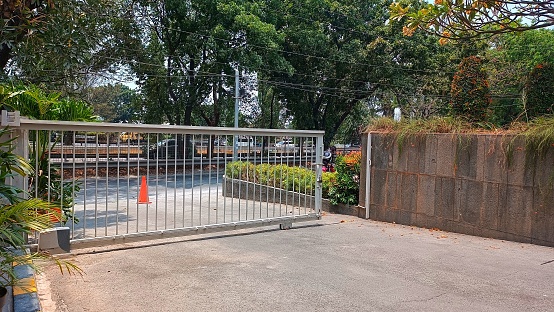 Jakarta, Indonesia - Oct 2023 : The fence of a building is made of iron and is slightly open with a traffic cone behind it.