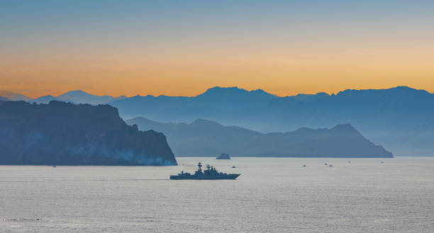 military ship on the background of mountains Selective focus. The military ship on the background of mountains shades of blue stock pictures, royalty-free photos & images
