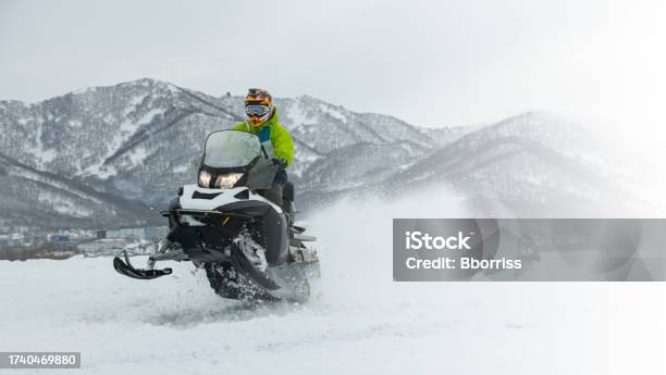 The Snowmobile In High Jump Above Track Stock Photo - Download Image Now - Snowmobile, Motion, Activity