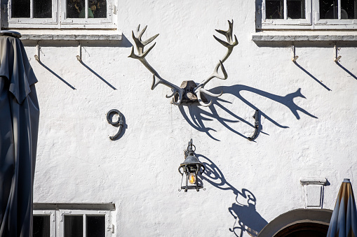 Dyrehaven, Denmark - September 4th 2023: Set of red deer antlers on a white wall of an old house called Peter Liep's House which is situated in Dyrehaven, which is a public park north of Copenhagen and an UNESCO World Heritage Site