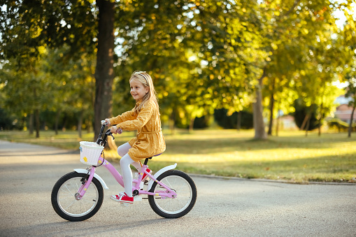 Little girl out for a ride on her bike in the park