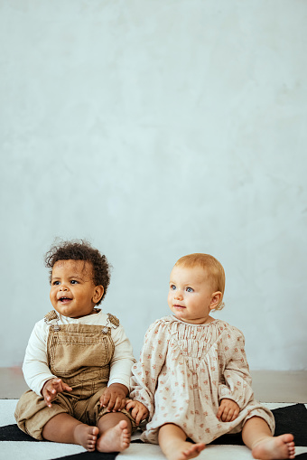 Multiracial babies sitting on the floor
