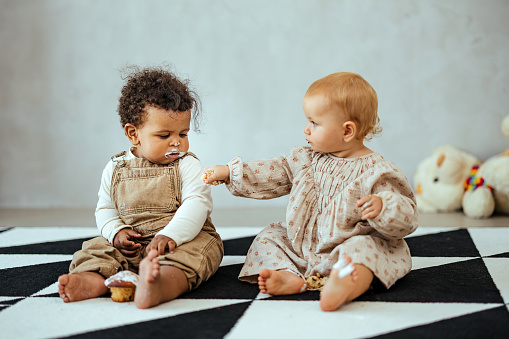 Multiracial babies sitting on the floor