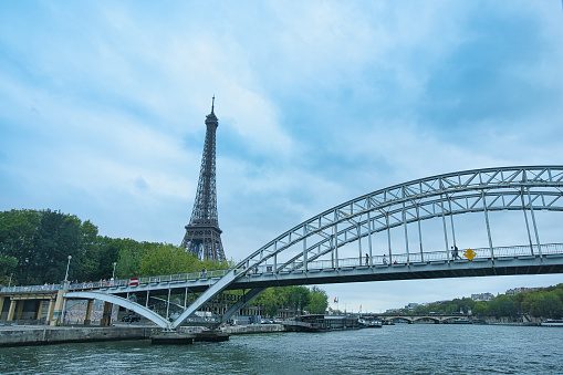 France, Paris 25.08.2023 Eiffel tower and Passerelle Debilly Bridge Bateaux Parisiens on seine river