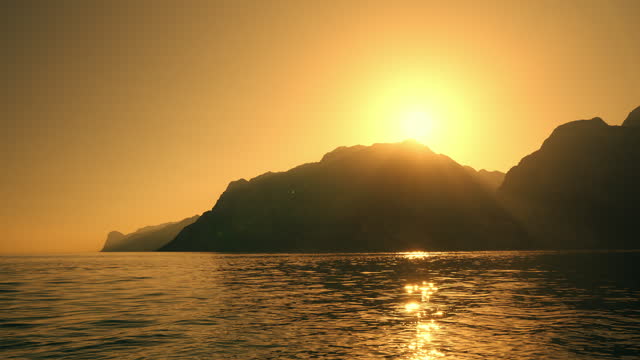 SLO MO Beautiful view of Sunset over Mountains and Lake Garda, Sun Shining on Water Surface