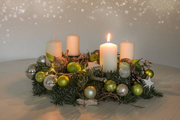 istock First Advent, wreath with one burning white candle and green Christmas decoration on a table, home decor for the first Sunday, copy space, selected focus 1740524891
