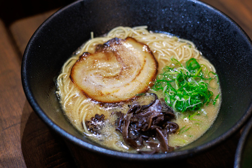 Japanese ramen served with various toppings such as flavoured egg, braised pork belly, char siu, dried seaweed, black fungus and spring onions