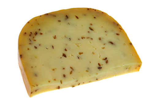 Piece of Gouda with cumin closeup on a white background